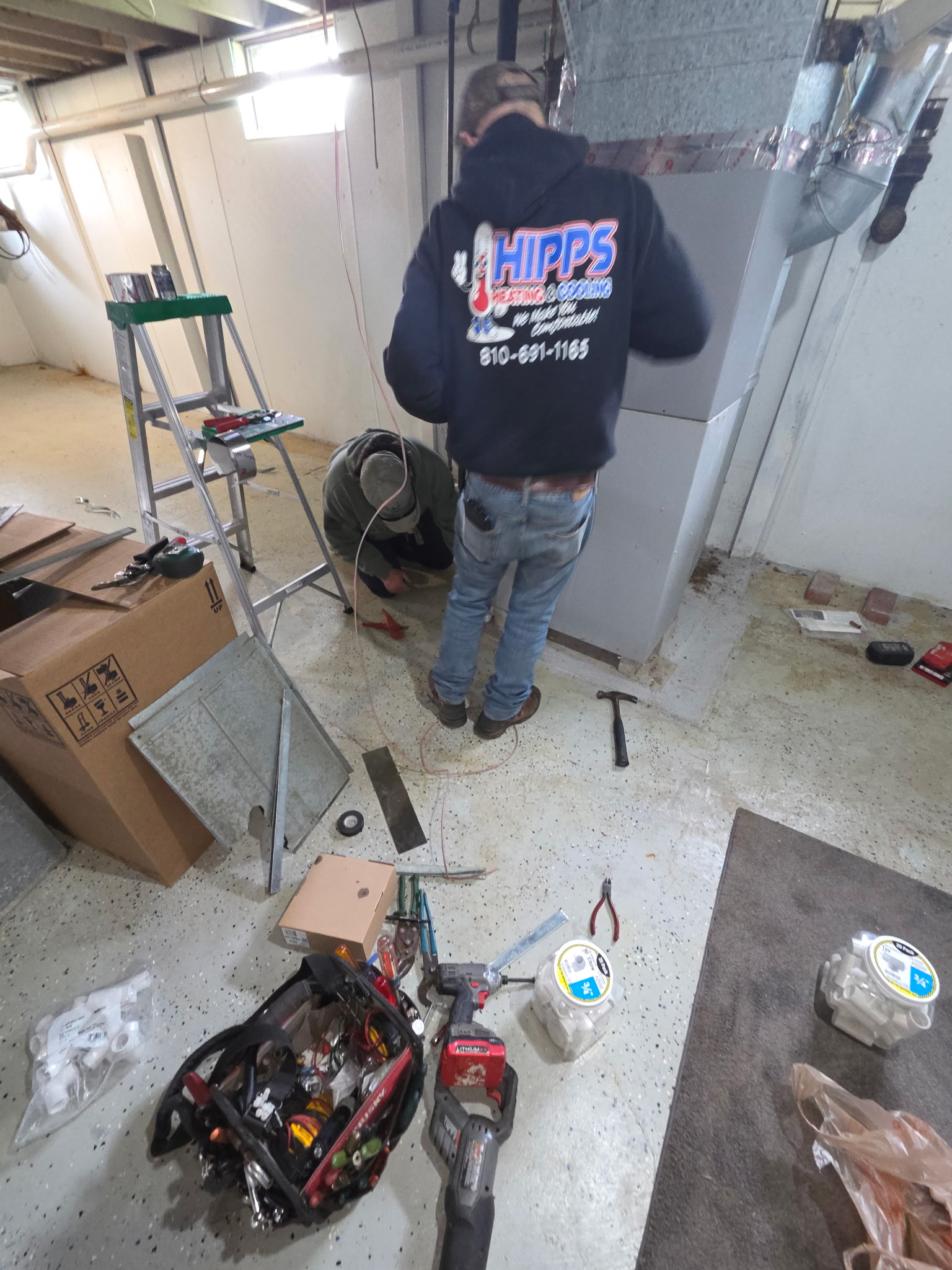 Hipps Heating and Cooling technician installing a furnace in Genesee County Michigan